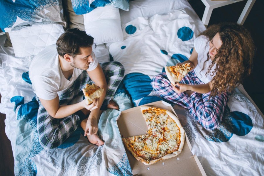 Парень и девушка едят пиццу