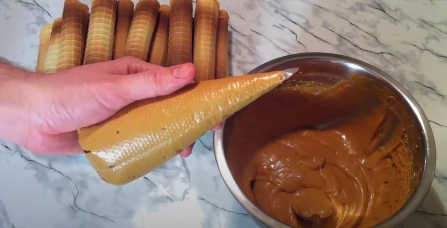 Вафельные трубочки со сгущенкой в руке